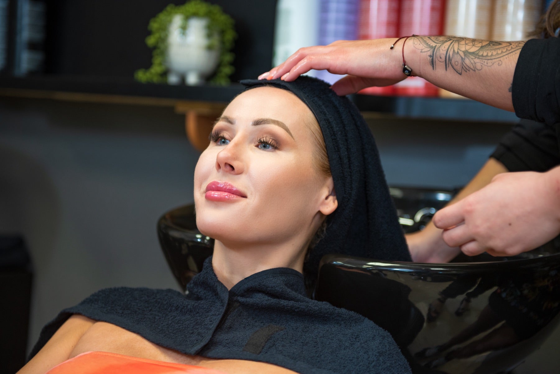 The black LOBA Style Wrap worn during a shampoo service.